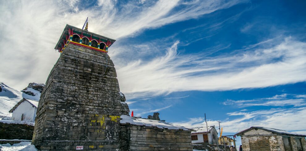 Snow-covered temple with vibrant decorations under a bright blue sky.